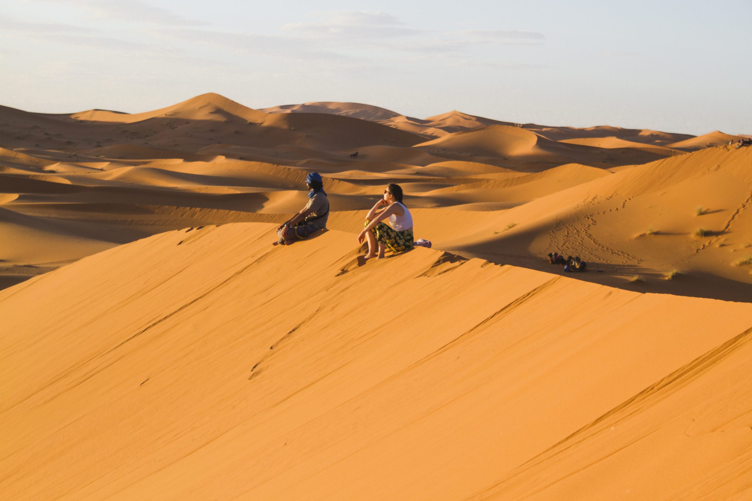 extreme-long-shot-two-people-sitting-top-dune